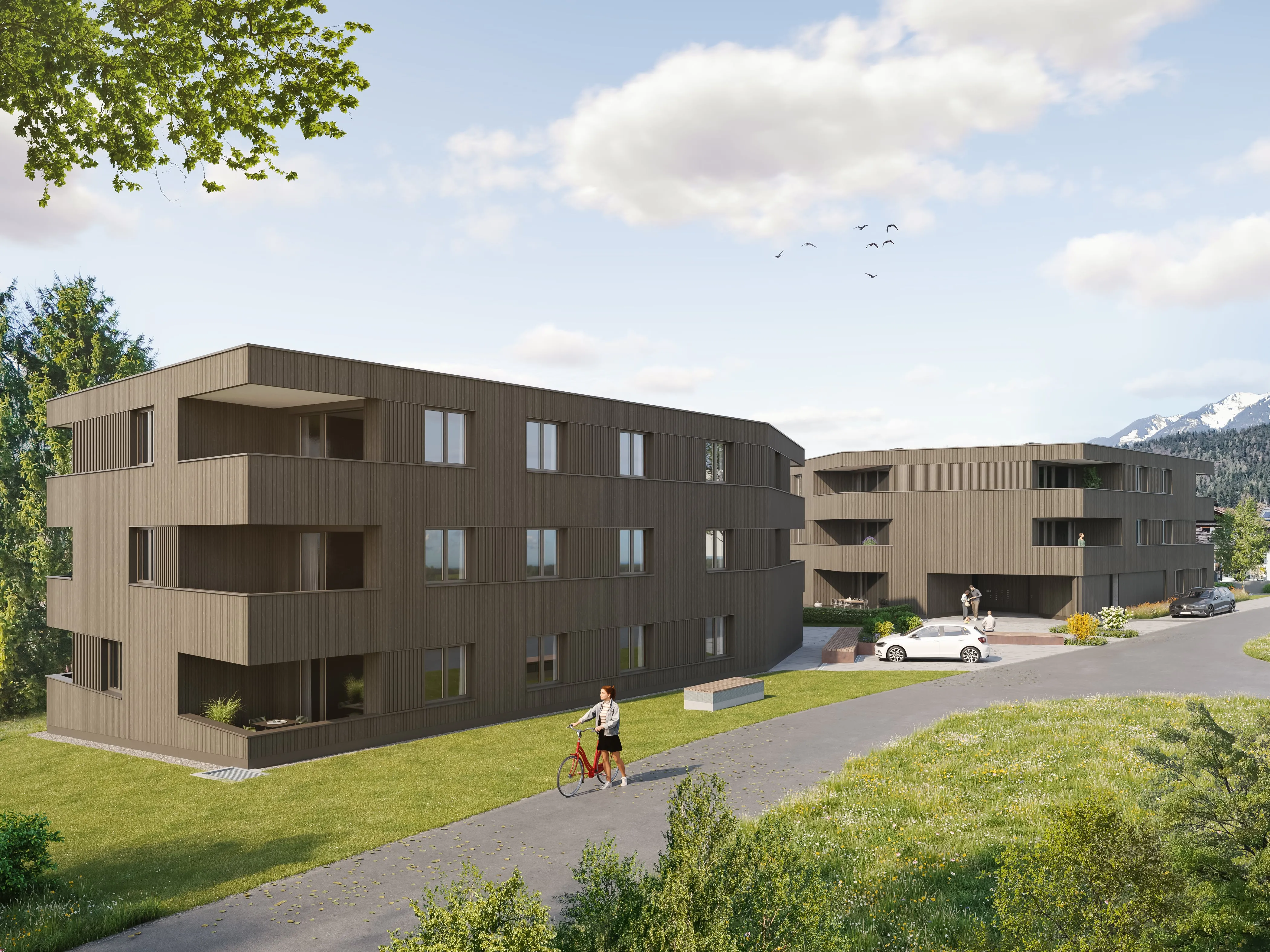 Die beiden dreigeschossigen Häuser von Stone Field 19 in Nüziders mit Grünfläche und Fußweg.